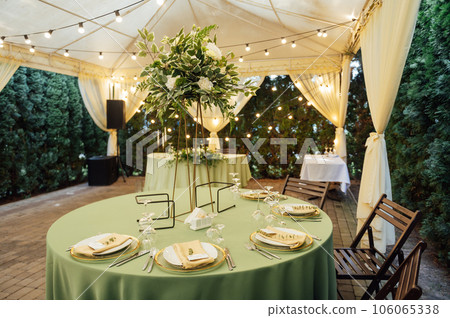 A beautiful vase of flowers on a table in a luxury restaurant. Wedding decorations A beautiful vase of flowers on a table in a luxury restaurant. Wedding decorations 106065338