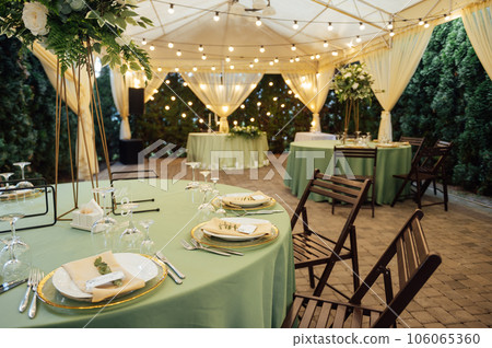 Open air wedding restaurant decorated with fresh flowers and premium dishes 106065360