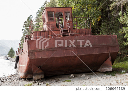 Rusty abandoned barge lays on the coast of Teletskoye lake Rusty abandoned barge lays on the coast of Teletskoye lake 106066189