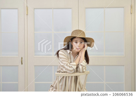 一個美麗的年輕女子穿著裙子坐在椅子上擺姿勢 106066536