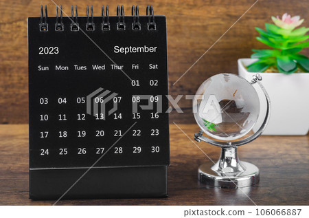 The September 2023 desk calendar for 2023 year Black color with a crystal globe against a wooden table background. The September 2023 desk calendar for 2023 year Black color with a crystal globe against a wooden table background. 106066887