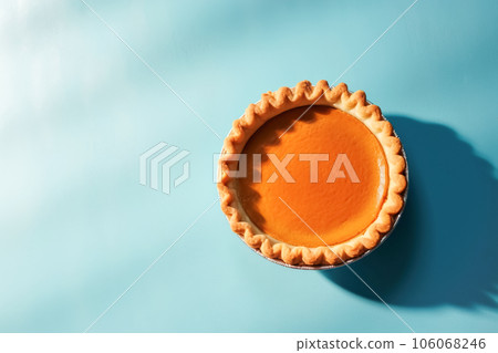 Festive homemade appetizing ripe pumpkin pie, pumpkin tart decorated with nuts, minimalistic blue background with hard shadows, top view. Traditional seasonal fall baking, Thanksgiving 106068246