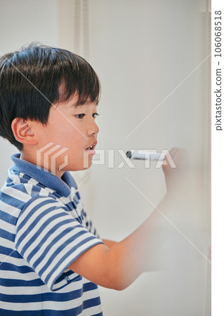Elementary school boy writing answers on the whiteboard 106068518