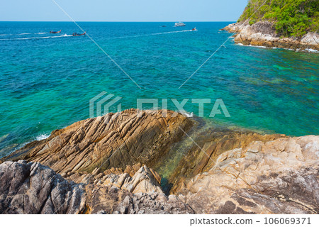 Boats go along Southwest rocky sea shore of Ko Lipe island, Thailand 106069371