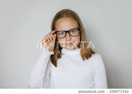 Pretty smart young brunette girl in glasses looking at camera Pretty smart young brunette girl in glasses looking at camera 106071502