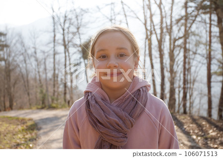 Cheerful child girl in purple scarf outdoor portrait Cheerful child girl in purple scarf outdoor portrait 106071513