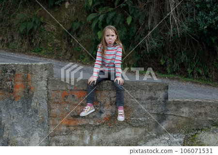Mischievous child girl grimacing outdoor Mischievous child girl grimacing outdoor 106071531