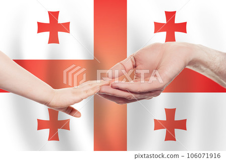 Georgian baby and parent hands on the background of flag of Georgia Help 106071916