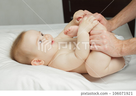 Adorable newborn baby with smiling face relaxing time doing belly massage by his father Adorable newborn baby with smiling face relaxing time doing belly massage by his father 106071921