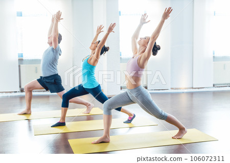 Three sporty people in the warrior I pose 106072311