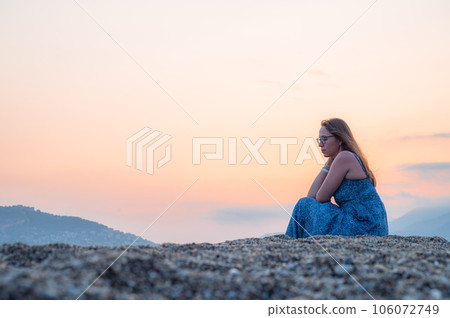 Woman sits on the beach and looks at the sea in Alanya city 106072749