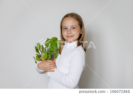 Child with green plant on white background 106072868