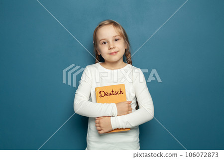 Child student girl with German language book on the background of blue chalkboard Child student girl with German language book on the background of blue chalkboard 106072873