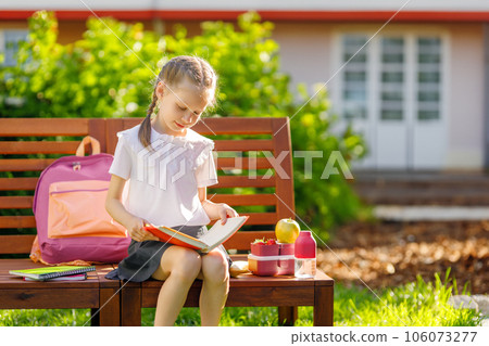 girl is having lunch sitting next to the school girl is having lunch sitting next to the school 106073277