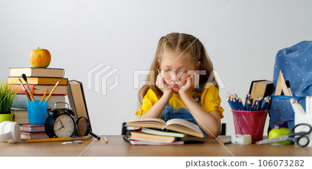 Thinking child is sitting at desk 106073282