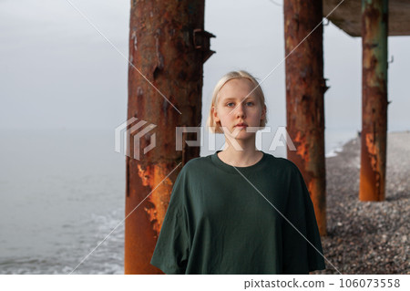 Blonde young adult woman in green dress outdoor portrait 106073558