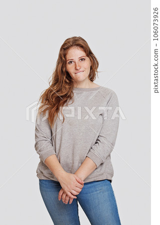 Funny woman in casual wear standing against white wall background, studio portrait 106073926