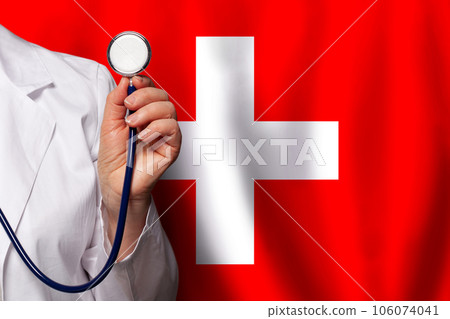 Swiss doctor's hand with stethoscope on the background of flag of Switzerland Medicine, 106074041