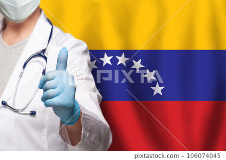 Venezuelan doctor's hand showing thumb up positive gesture on flag of Venezuela background Venezuelan doctor's hand showing thumb up positive gesture on flag of Venezuela background 106074045
