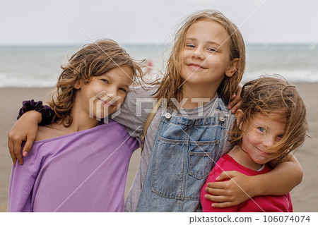 Happy kids portrait. Young girls smiling looking at camera outdoor. Child 7, 8 and 10 years old Happy kids portrait. Young girls smiling looking at camera outdoor. Child 7, 8 and 10 years old 106074074