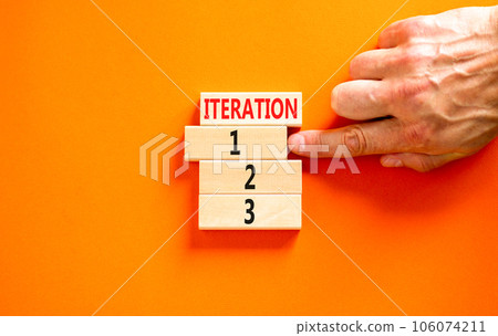 Time to iteration 1 symbol. Concept word Iteration 1 2 3 on wooden block. Businessman hand. Beautiful orange table orange background. Business planning and time to iteration 1 concept. Copy space. 106074211
