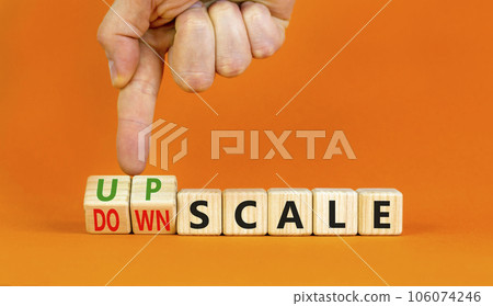Upscale or downscale symbol. Concept words Upscale or Downscale on wooden cubes. Beautiful orange table orange background. Businessman hand. Business upscale or downscale concept. Copy space. 106074246