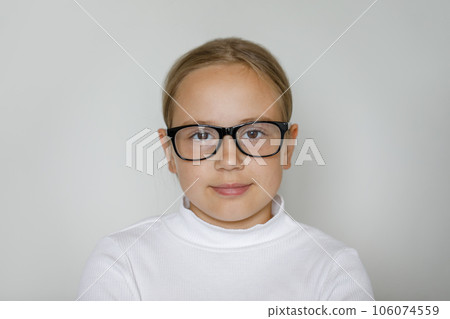 Clever child girl in glasses on white studio wall background 106074559