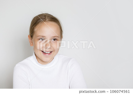 Portrait of happy young girl laughing on white studio wall background Portrait of happy young girl laughing on white studio wall background 106074561
