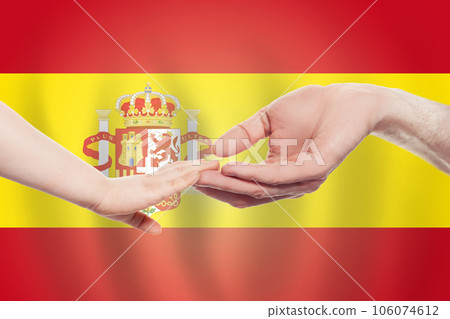 Spanish baby and parent hands on the background of flag of Spanish Help, aid, charity concept 106074612