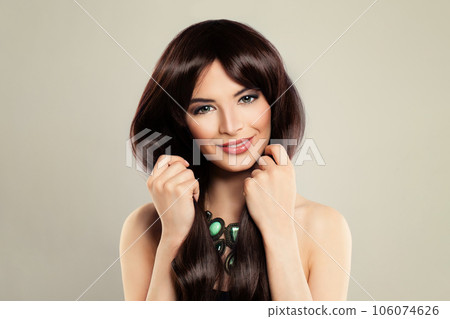 Happy smiling brunette model woman with long straight smooth hair, studio portrait 106074626