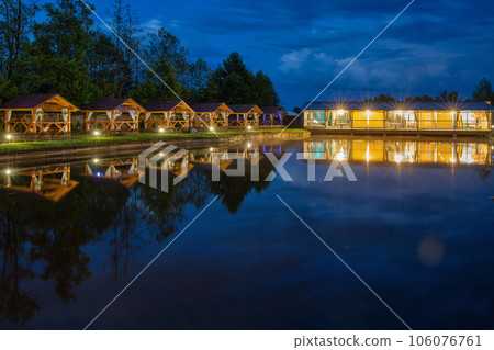 evening restaurant and wooden gazebos for relaxing by the lake 106076761
