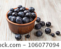 Blueberries in a brown plate on a wooden background. 106077094