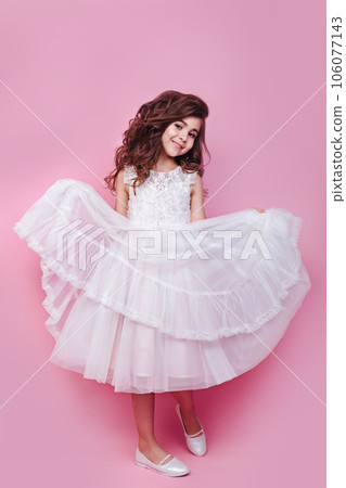 Full size body length little cute kid girl 5-6 years old wears pink dress dancing on pink background 106077143