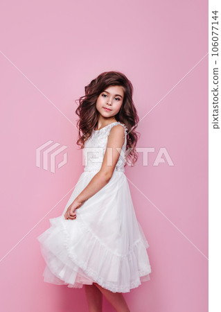 Full size body length little cute kid girl 5-6 years old wears pink dress dancing on pink background 106077144