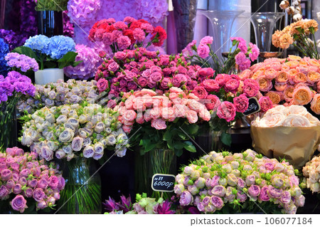 Bouquets of various flowers are displayed in a shop window 106077184
