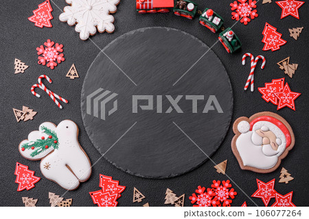 Empty dark ceramic plate with elements of Christmas decorations 106077264