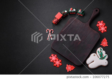 Empty dark ceramic plate with elements of Christmas decorations 106077275