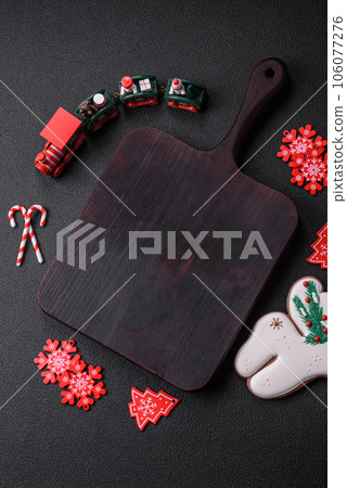 Empty dark ceramic plate with elements of Christmas decorations 106077276