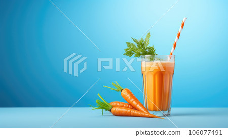 A glass with carrot juice and a straw 106077491