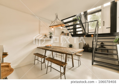 a dining table and chairs in a small room with stairs leading up to the second floor, as well as possible a dining table and chairs in a small room with stairs leading up to the second floor, as well as possible 106078408