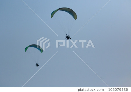 two paraglider flying over clear blue sky 106079386