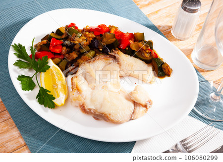 Roasted blue shark steak with vegetable saute, lemon and greens 106080299