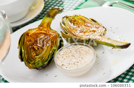 Roasted halves of artichoke with sea salt 106080351