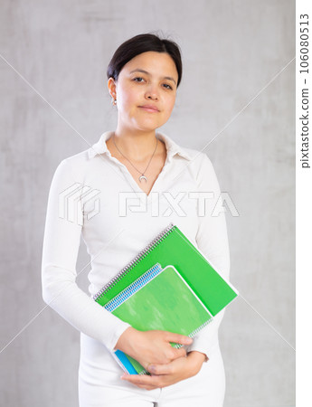 Student girl with several notebooks for writing poses in studio. Student girl with several notebooks for writing poses in studio. 106080513