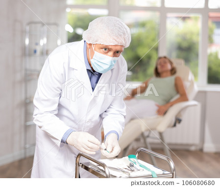 Senior male nurse makes preparations before blood drawing for analysis. Laboratory, emergency medicine 106080680