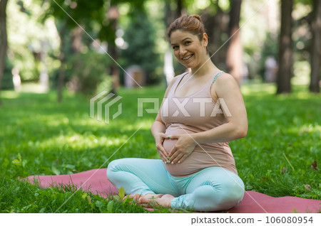 Prenatal yoga. Caucasian pregnant woman doing butterfly pose in the park. Prenatal yoga. Caucasian pregnant woman doing butterfly pose in the park. 106080954
