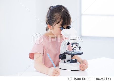 Elementary school girl looking into a microscope 106081133