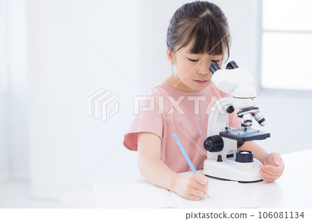 Elementary school girl looking into a microscope 106081134