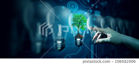 Human hand pointing Tree in the Light bulb against nature with digital convergence and technology background. Ecology, Energy, Environment, Green Technology, and IT ethics Concept. Human hand pointing Tree in the Light bulb against nature with digital convergence and technology background. Ecology, Energy, Environment, Green Technology, and IT ethics Concept. 106082006