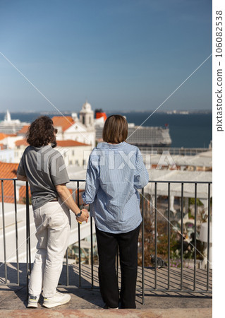 Back view of romantic hipster couple in love holding hands while walking on old city street Back view of romantic hipster couple in love holding hands while walking on old city street 106082538
